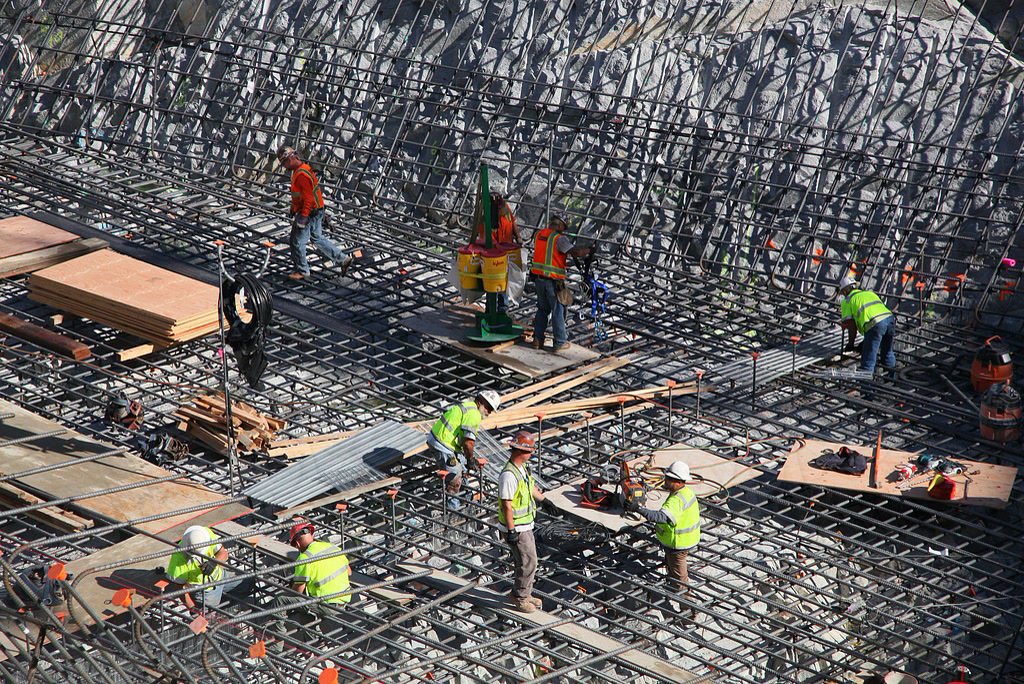 Workers tying a reinforcing steel mat on site before a concrete pour