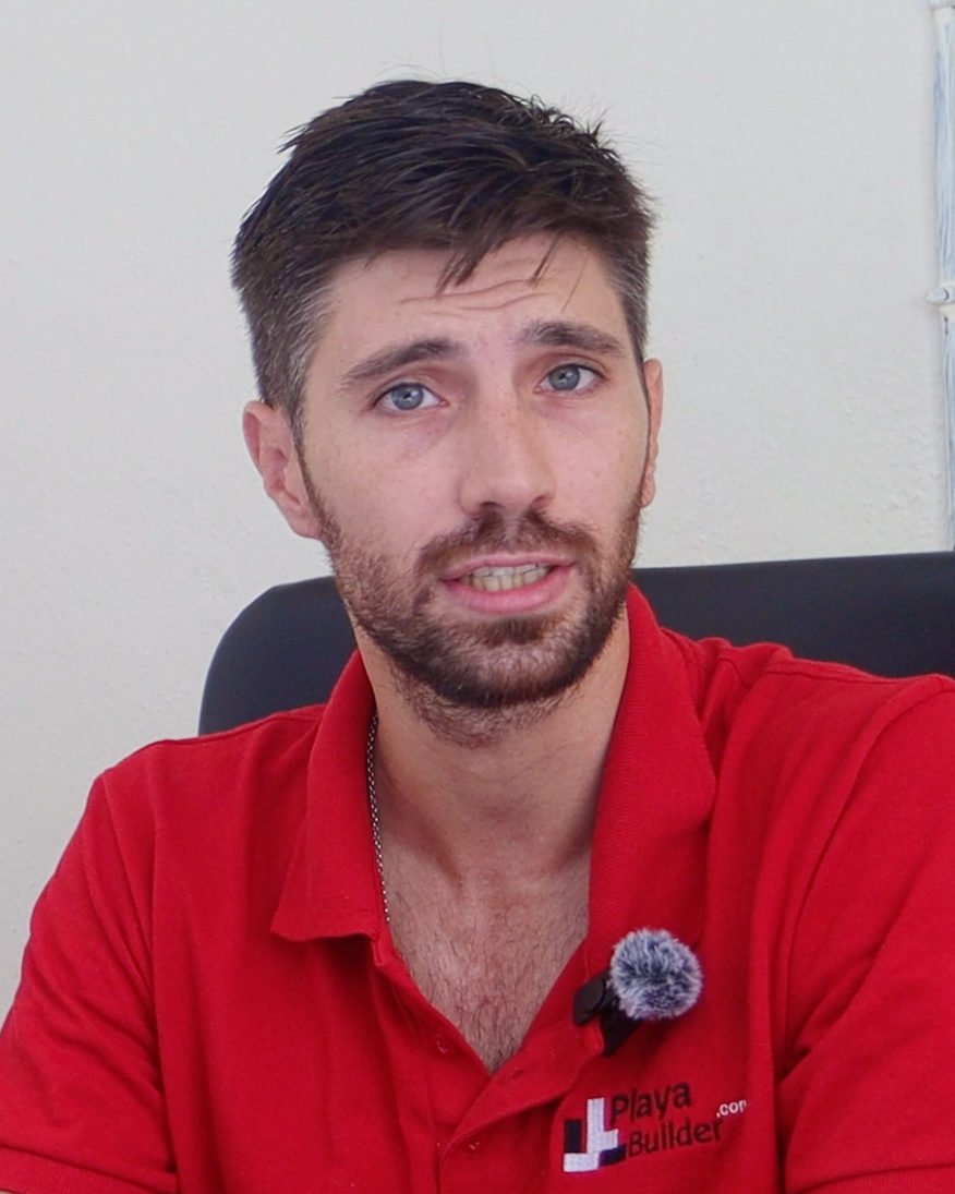Portrait of Andrés wearing a red PlayaBuilder polo shirt.
