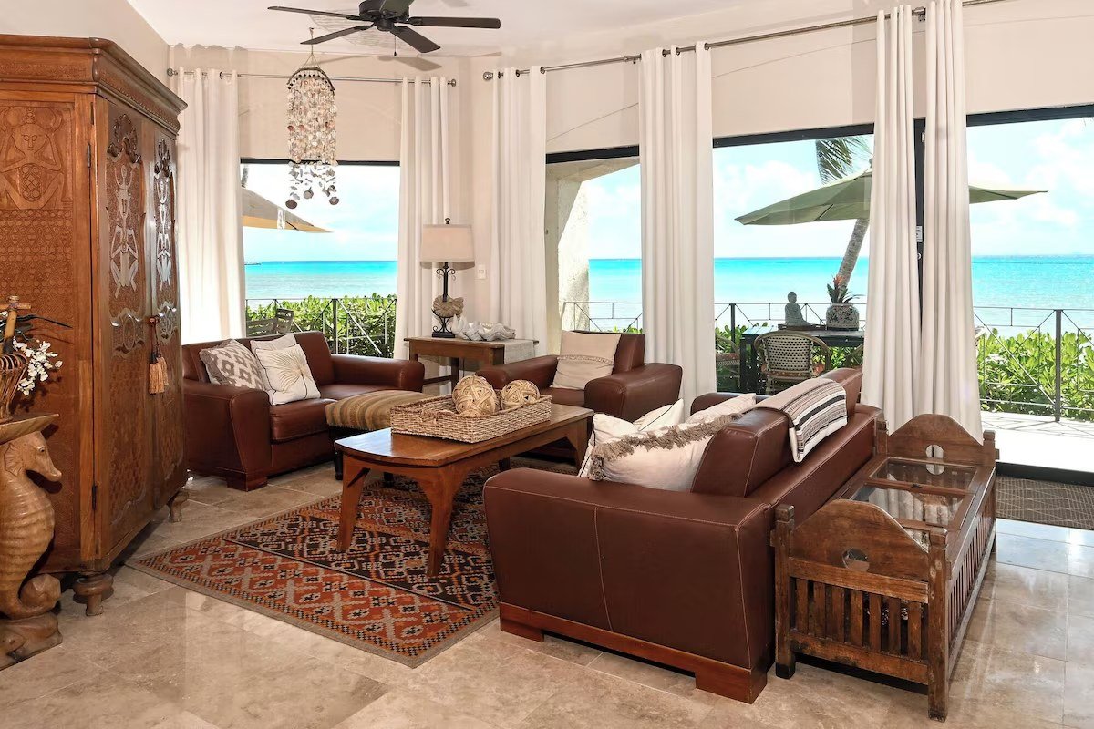 Living room of a beachfront condominium in downtown Playa del Carmen, with travertine floors and ocean views.