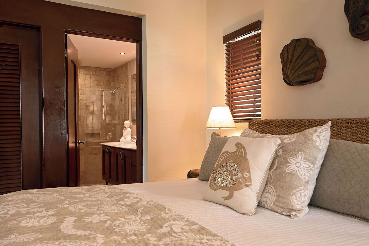 Primary bedroom with ensuite bathroom in a beachfront condo in Playa del Carmen.