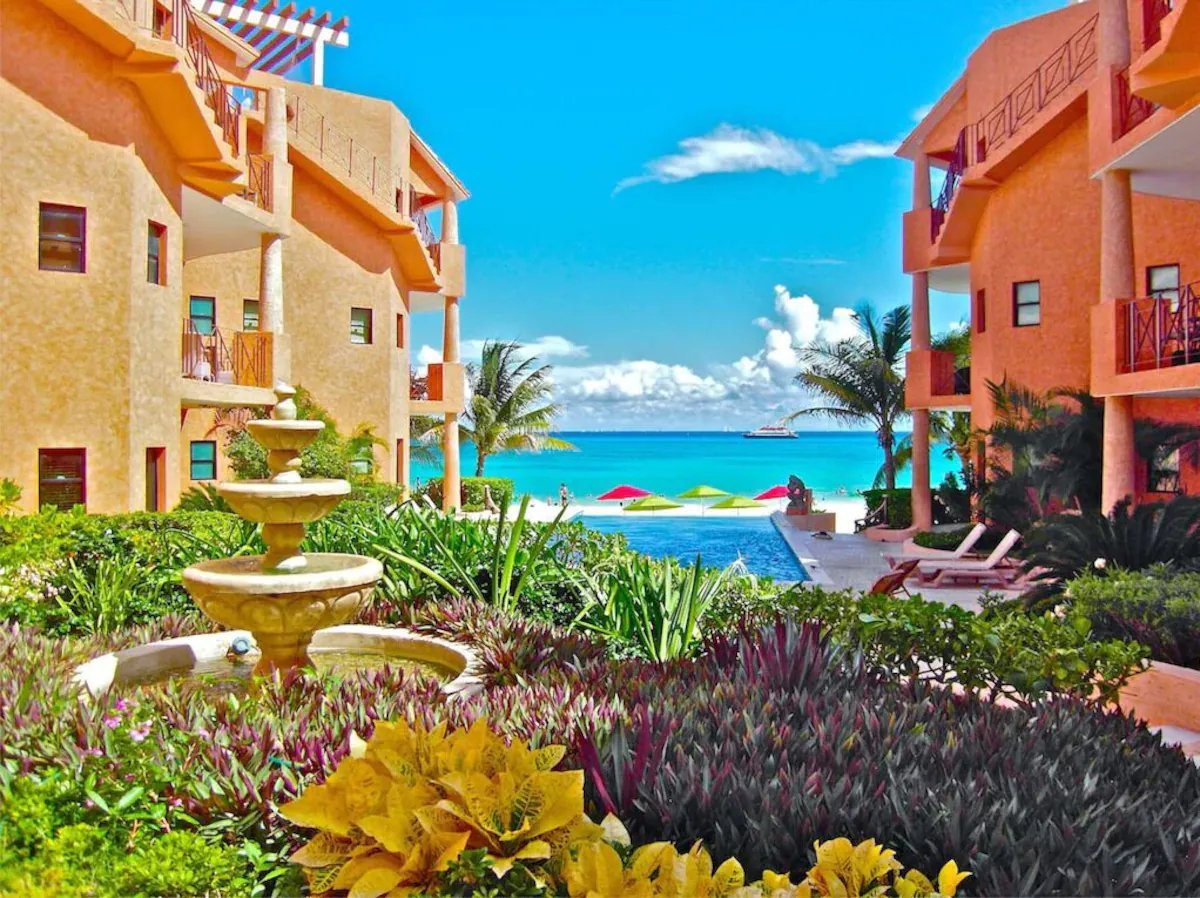 Garden courtyard, fountain and pool of a beachfront condominium in Playa del Carmen, with the Caribbean beyond.