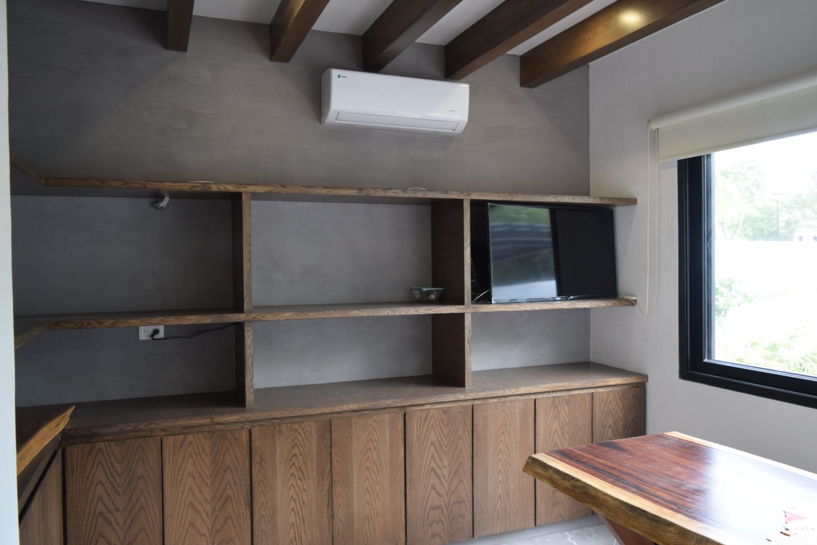 Kitchen at Casa Brisas in Playacar with timber cabinetry, open shelves, exposed ceiling beams and large windows.