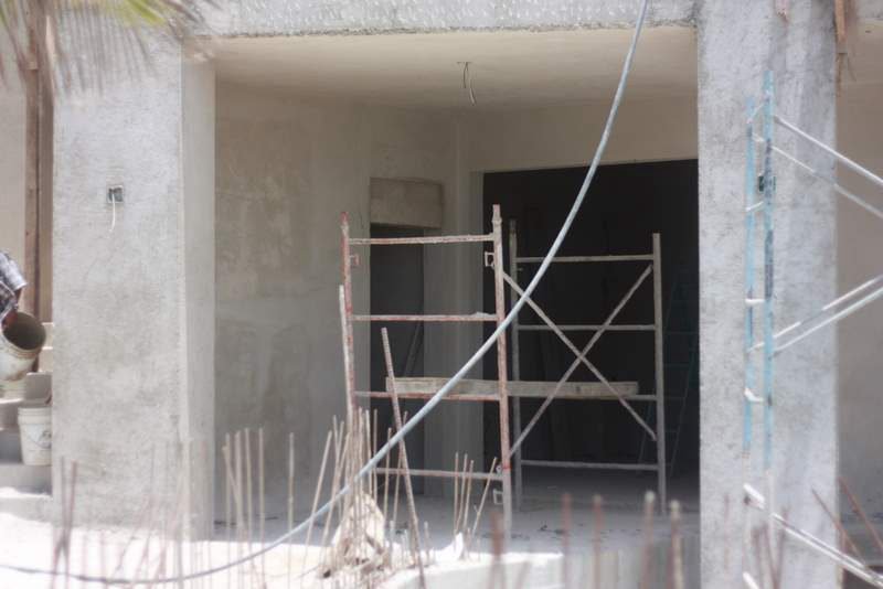 Interior under construction with scaffolding and unfinished wall openings.